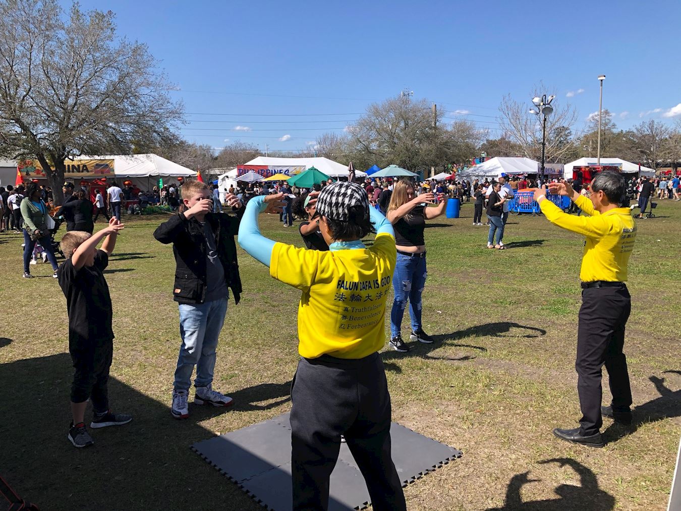 '图1:游客在活动现场学炼法轮功。'