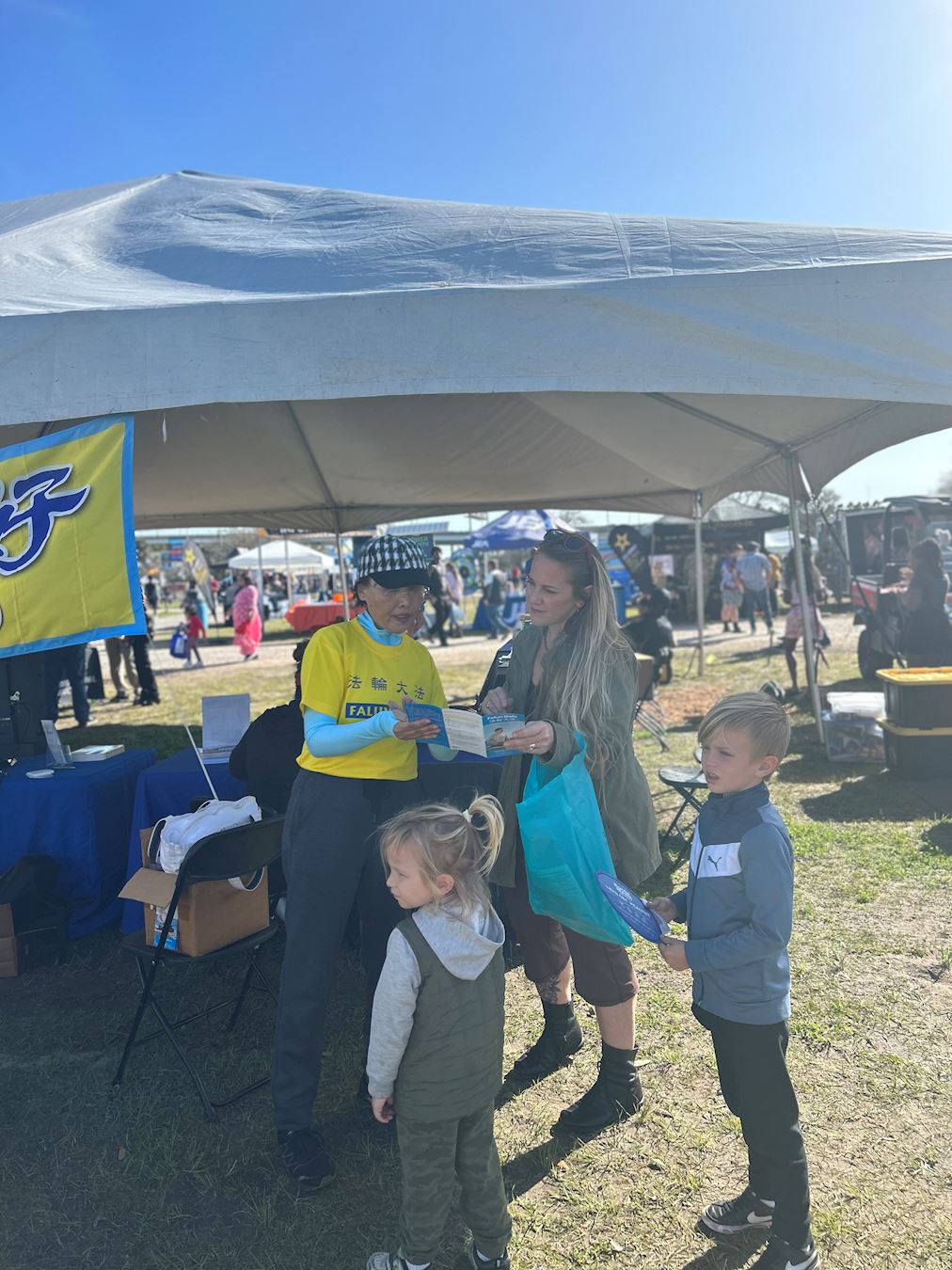 '图3:一位母亲和两个孩子对法轮大法非常感兴趣。'