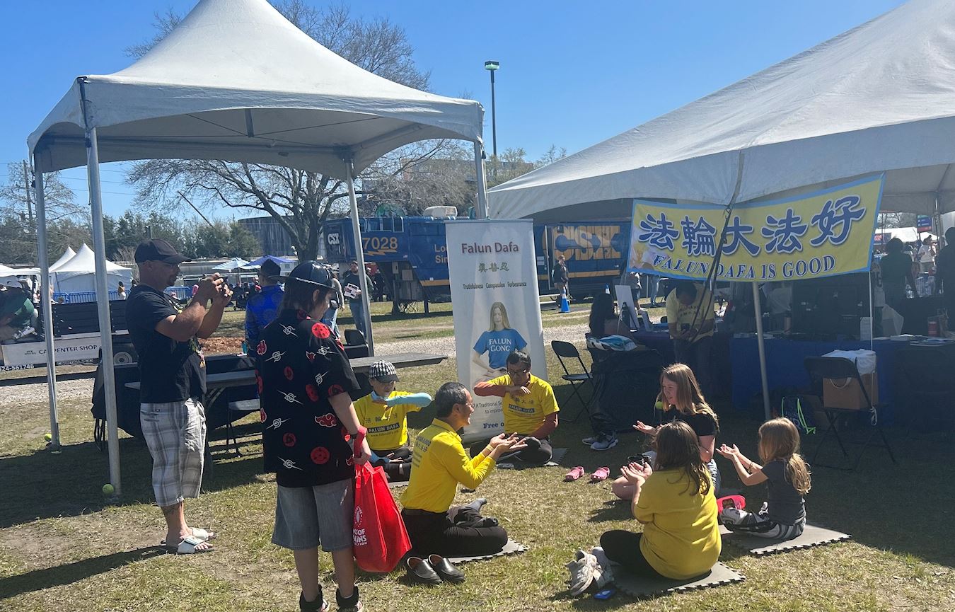 '图4:三个女孩正在学炼第五套法轮大法——神通加持法,她们的父亲在一旁给她们录制视频。'