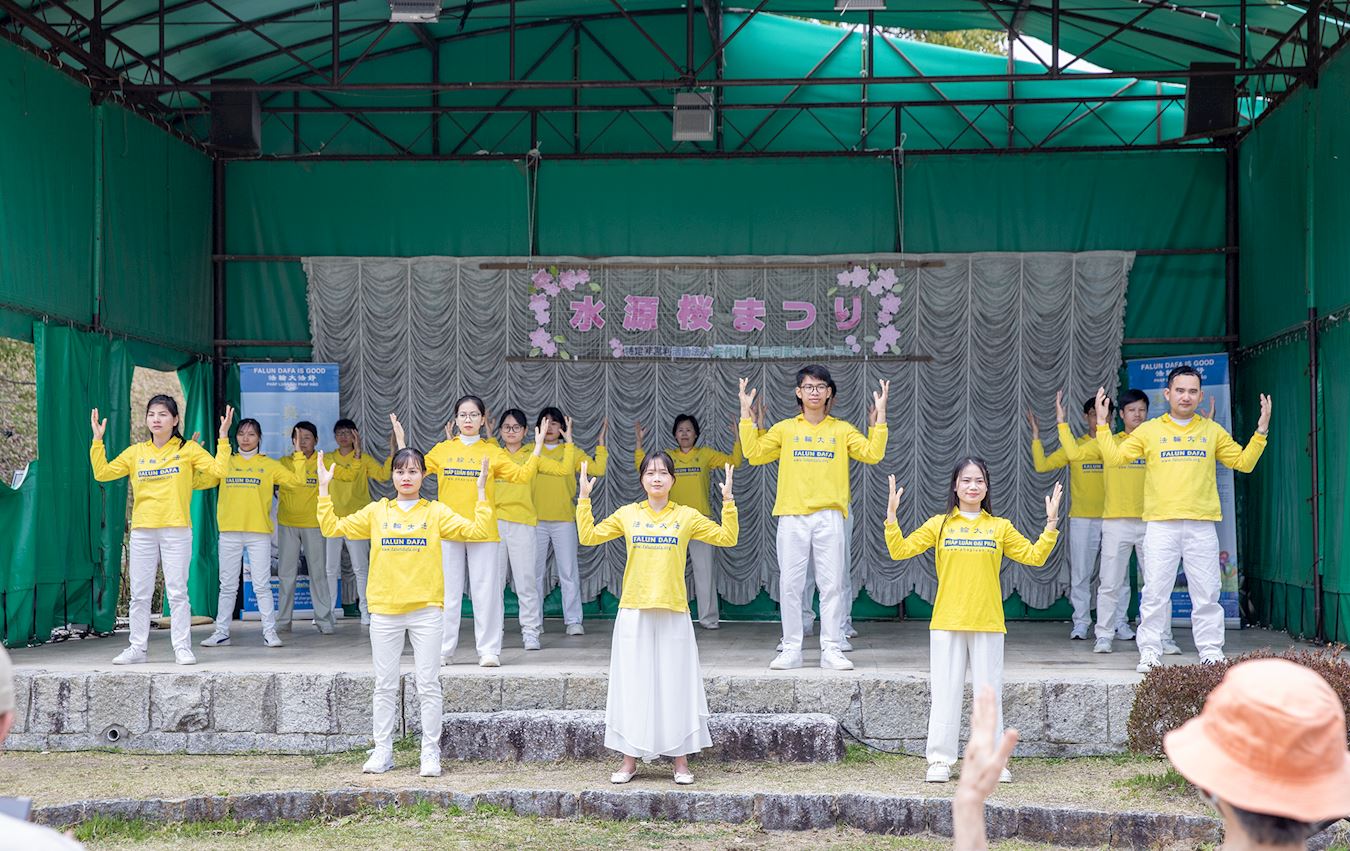 '图6~7:在丰田市水源公园樱花节的舞台上法轮功学员们进行功法展示'