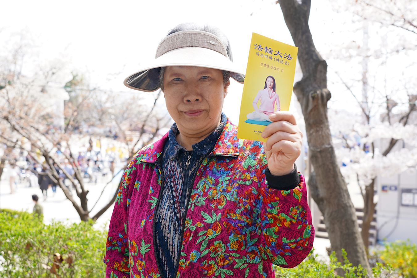 '图5:市民李玉惠(Lee Okhui)手拿法轮功的真相传单'