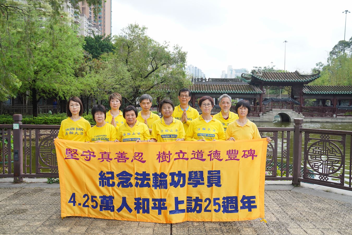 '图1:香港美孚和荔枝角炼功点的法轮功学员在集体炼功之后,拉起横幅,纪念四·二五万人和平上访二十五周年。'