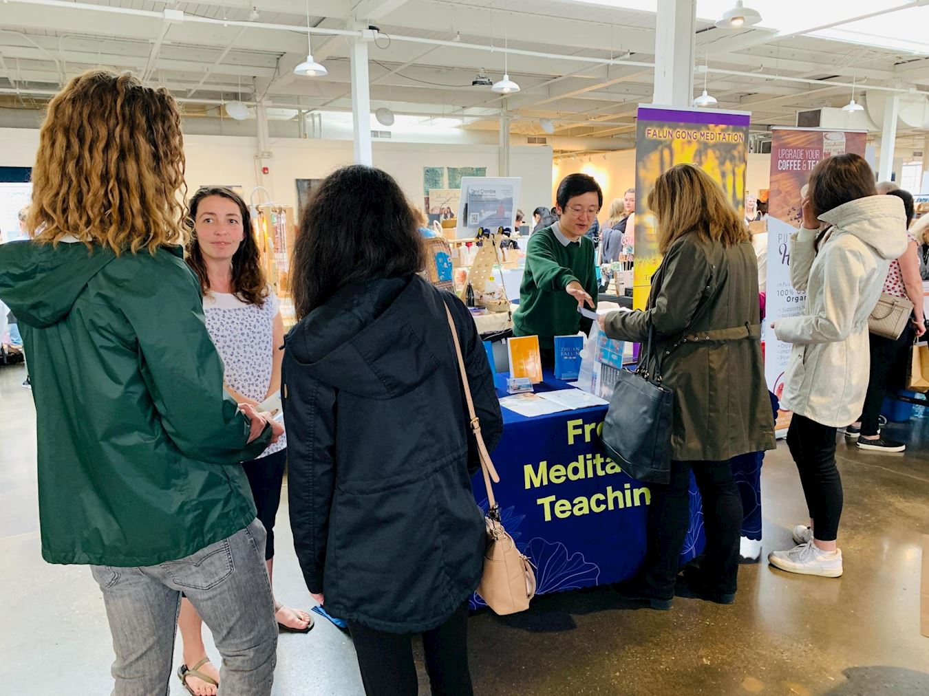 '图1~3:人们来展位了解法轮功,学习功法。'