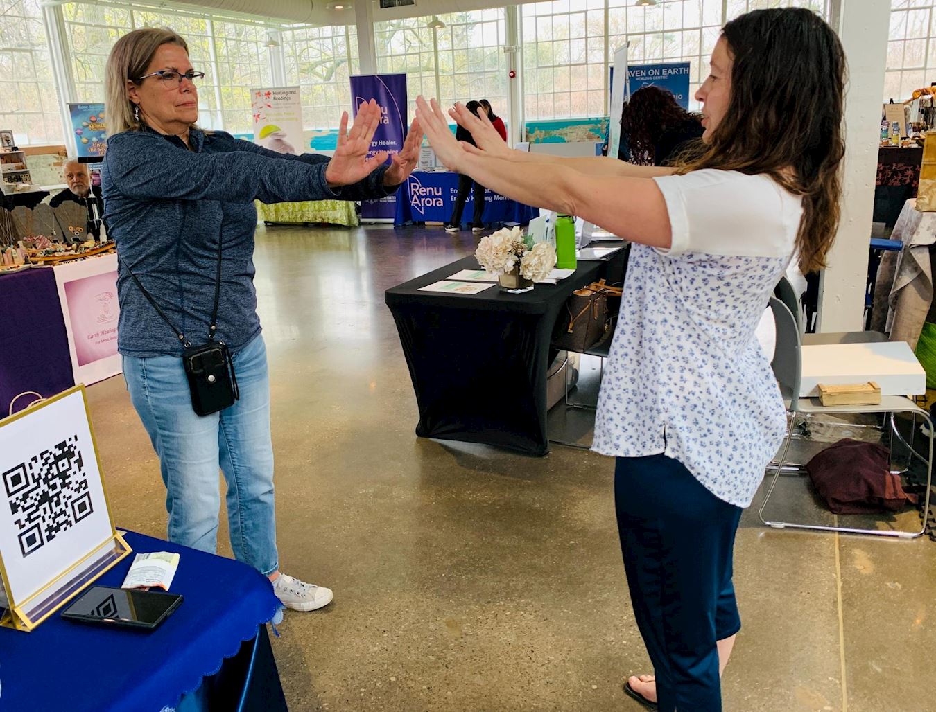 '图6:海伦在法轮大法展位上学炼了功法。炼功时,她不仅感到身体彻底放松,还感受到能量在她的体内运行。'