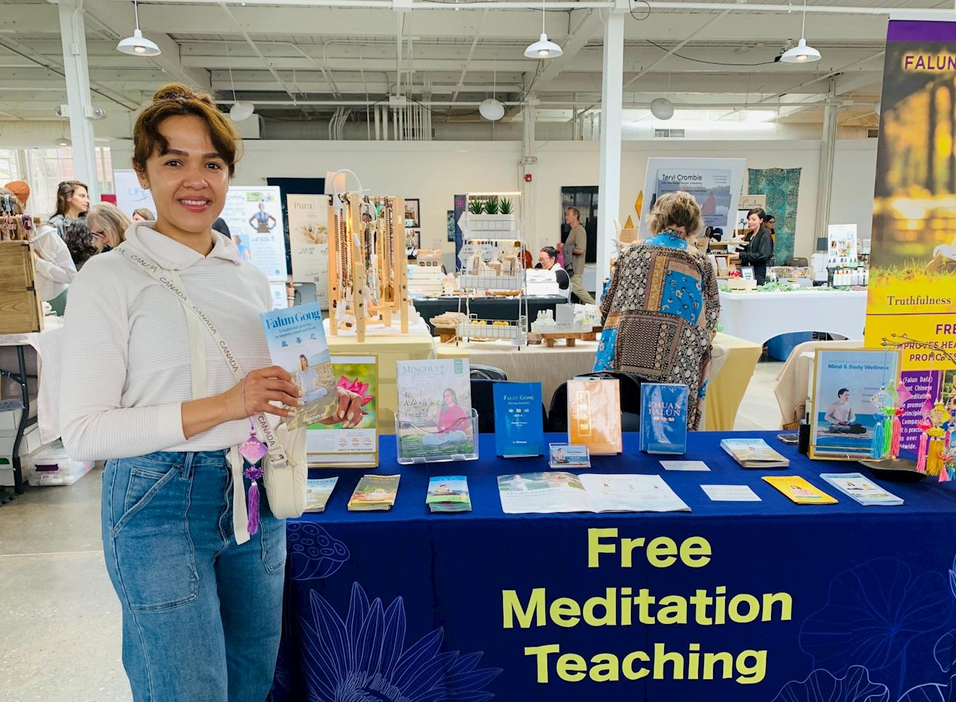 '图7:凯瑟琳在法轮大法展位上学炼了第一至三套功法后,她感到体内有股热乎乎的能量。'