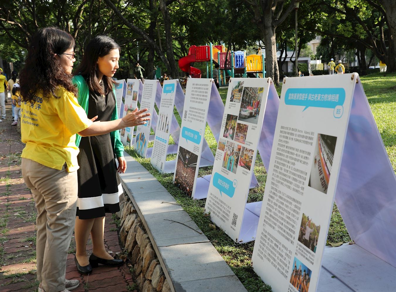 '图11:法轮功学员向参观真相图片的市民导览解说。'