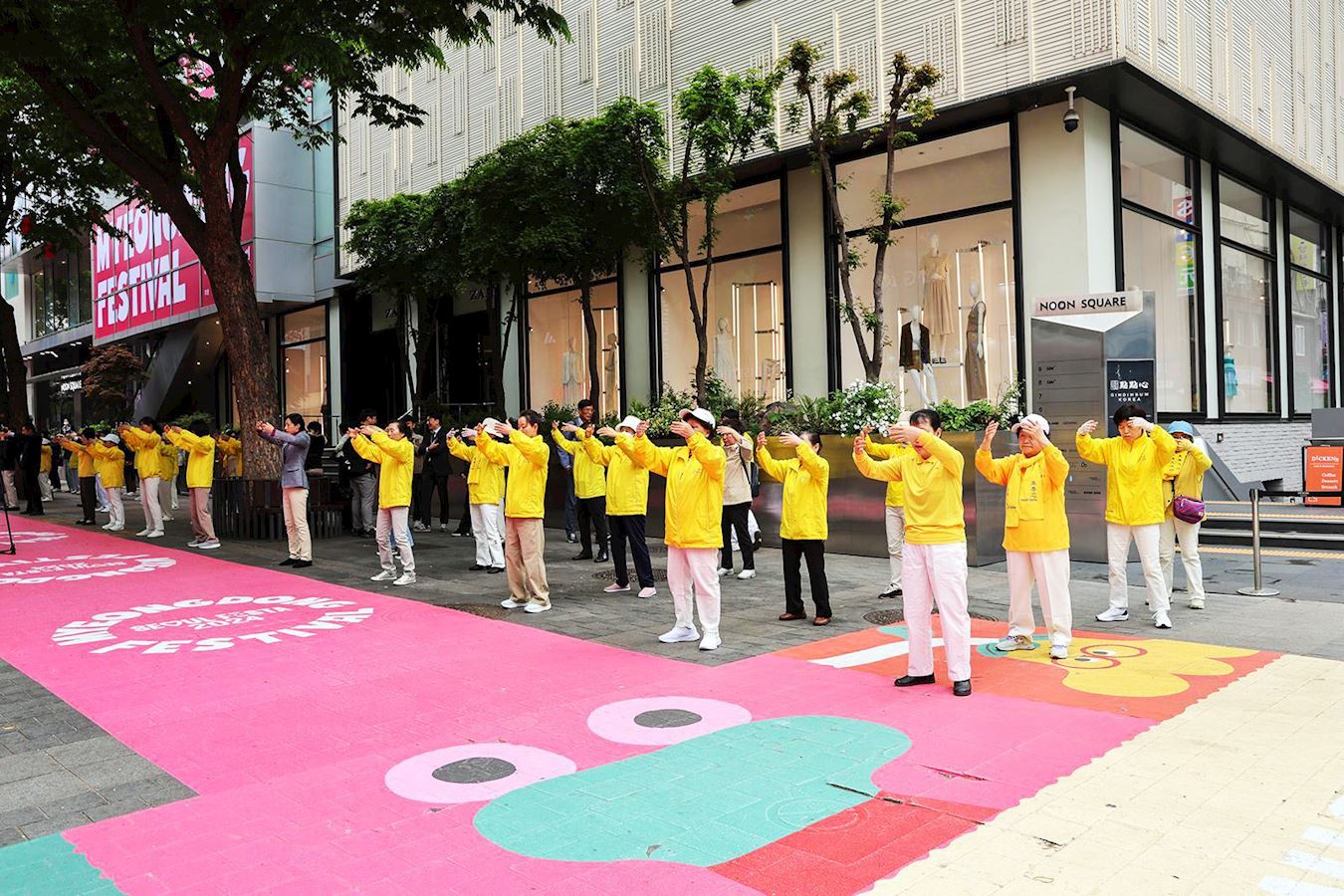 '图2:集会前,部份法轮功学员们在路边整齐列队集体炼功展现法轮大法的美好。'