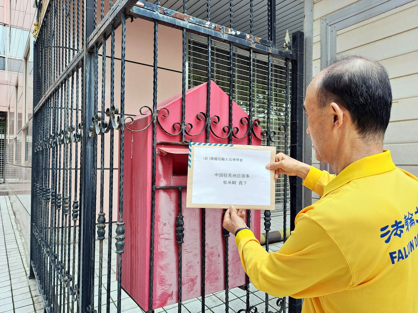 '图6:韩国法轮大法佛学会成员将相关声明书投进中共驻光州总领事馆信箱。'