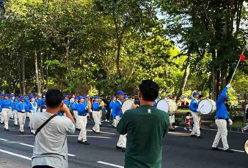 图5~6:观众举起手机,记录下法轮功学员游行的场景。
