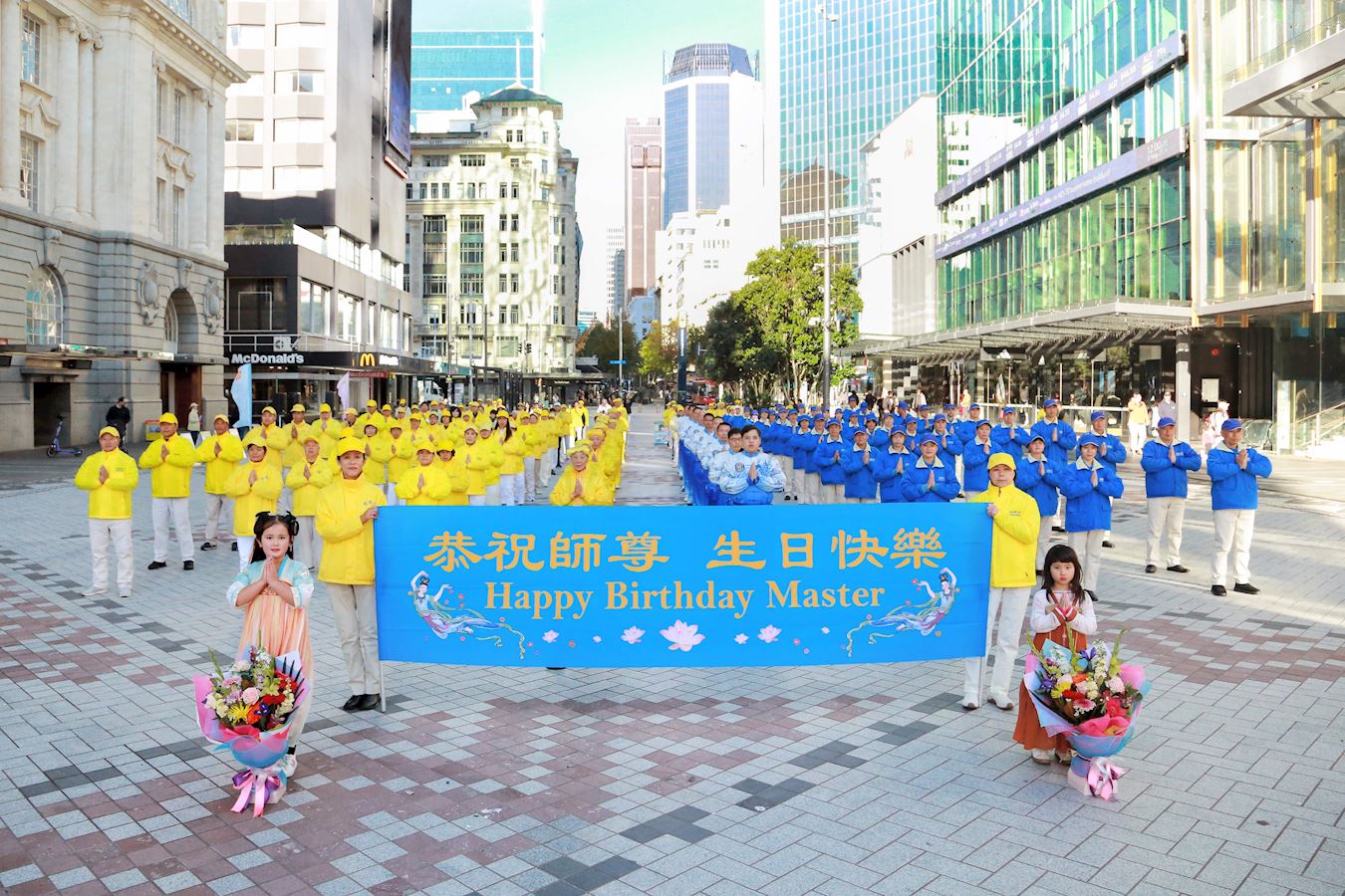 '图1:二零二四年五月十一日,新西兰法轮功学员在奥克兰市中心伊丽莎白(Elizabeth Square)广场庆祝世界法轮大法日,恭祝伟大的师尊生日快乐。'