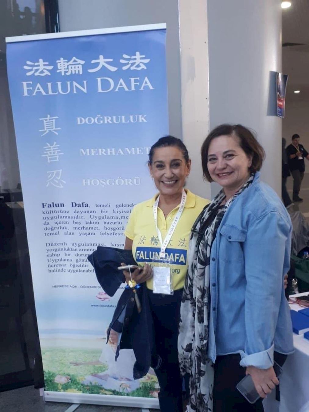 '图4:土耳其驻澳大利亚墨尔本前总领事古尔滕·阿桑(右)参观法轮大法展位。'