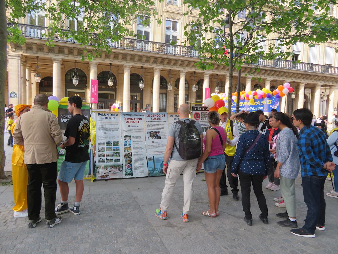 '图5~6:在柯莱特广场,游人民众观看法轮功展板,了解真相。'