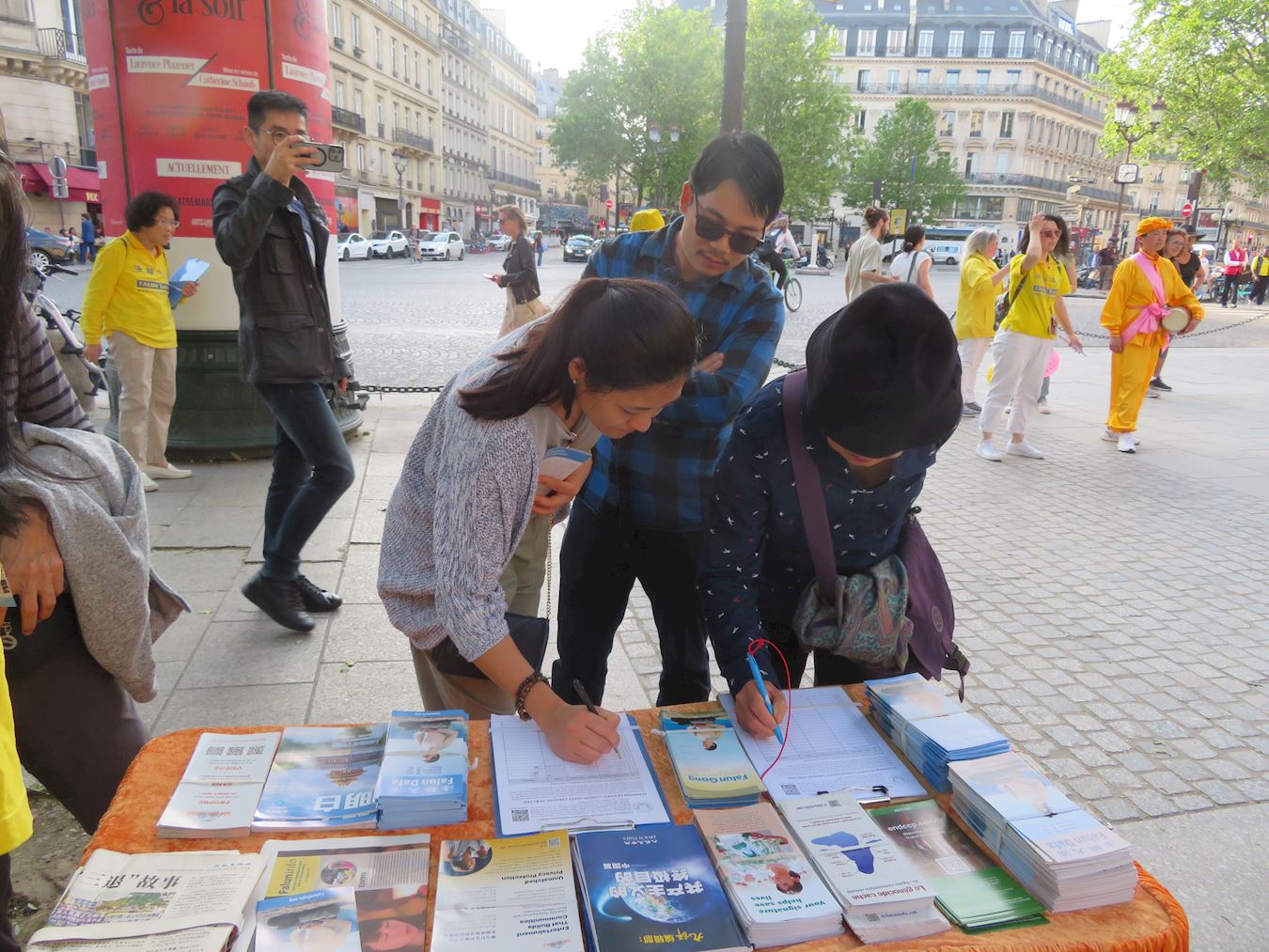 '图8~11:人们在请愿书上签字,支持法轮功学员的反迫害行动。'