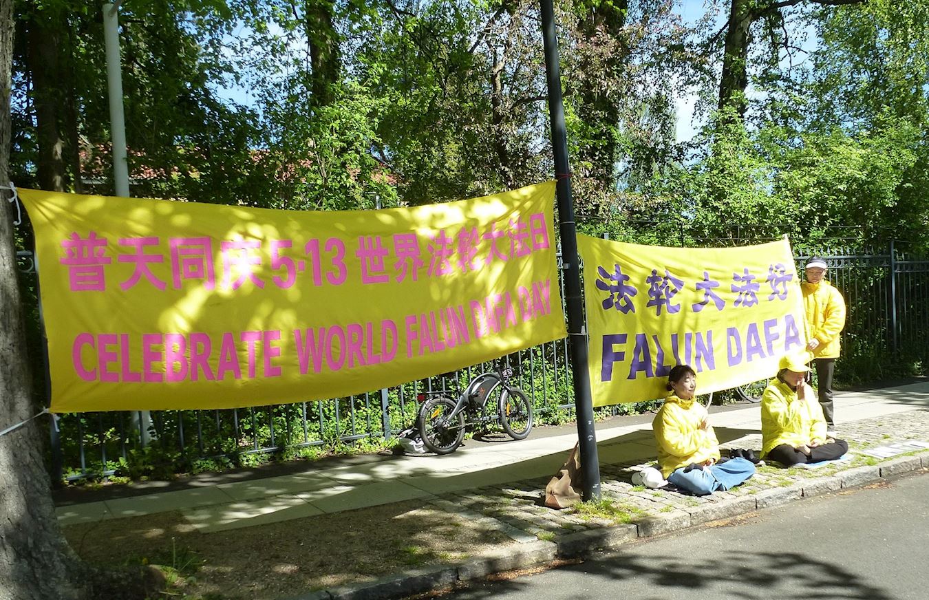 '图13:学员在中共使馆前煉功、講真相,向使馆工作人员传递真相信息。'