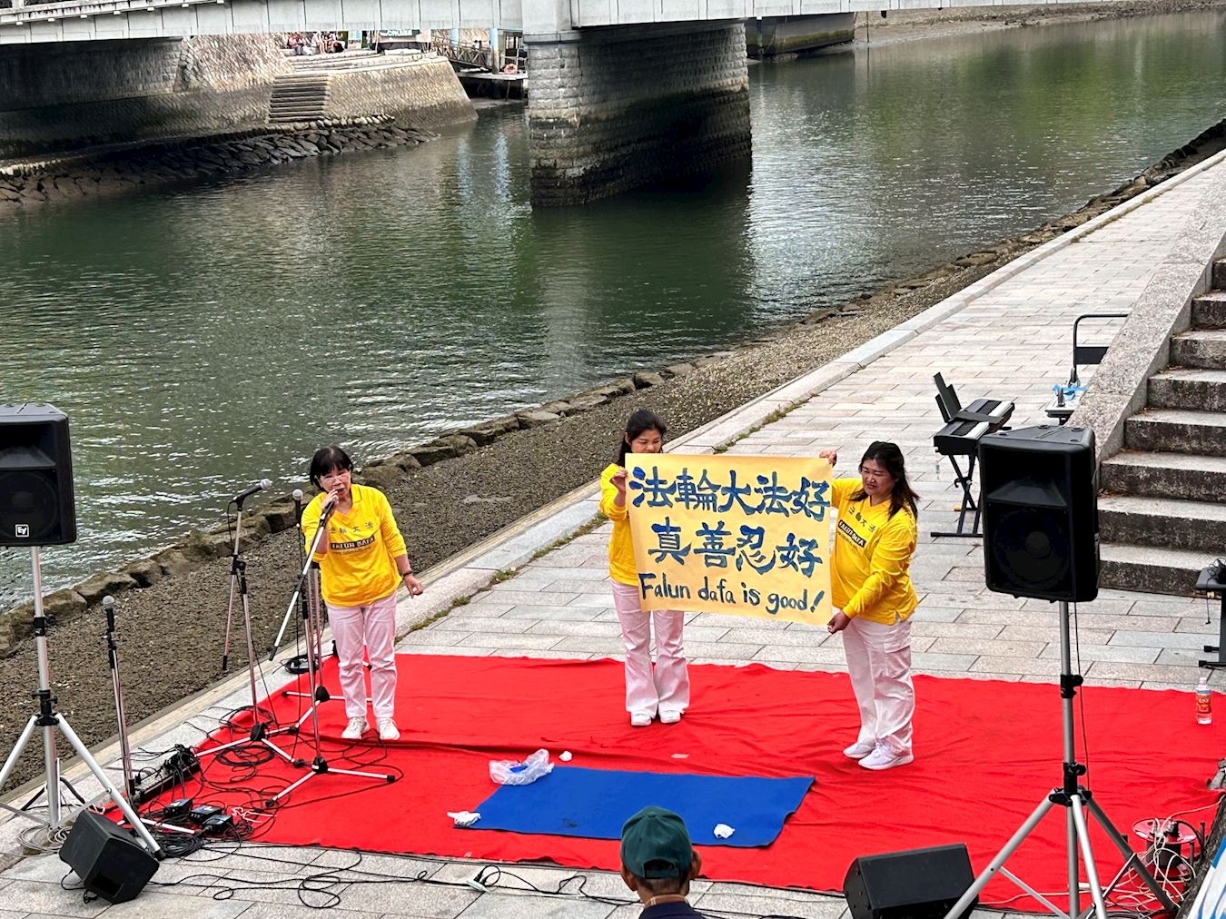 '图4:法轮功学员向观众展示刚刚完成的书法作品“法轮大法好、真善忍好”'