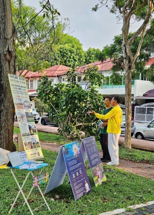 '图5:法轮功学员郭先生向路人介绍法轮大法。'