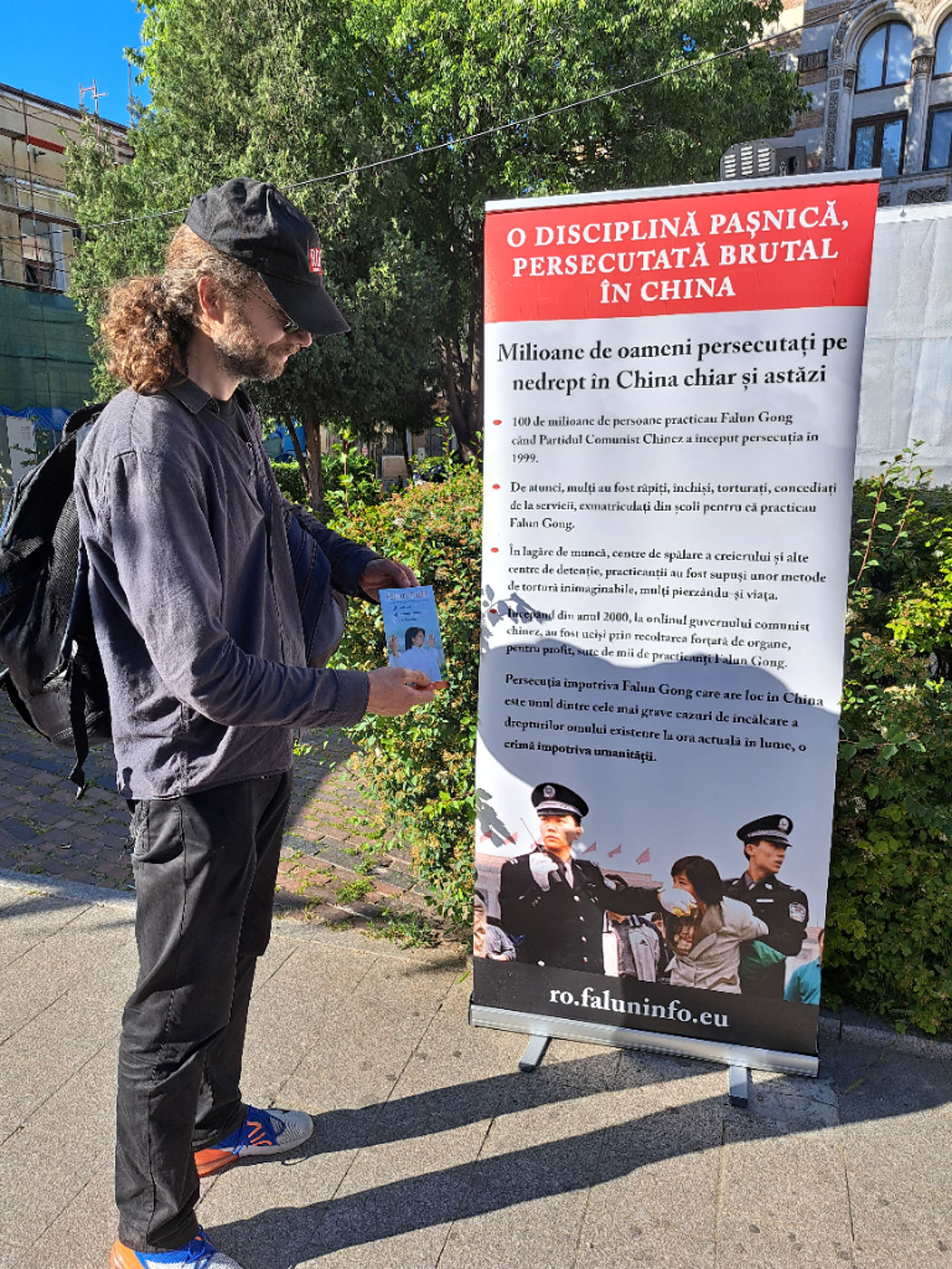 图3:米海在法轮功展位拍照,对学员表示支持。