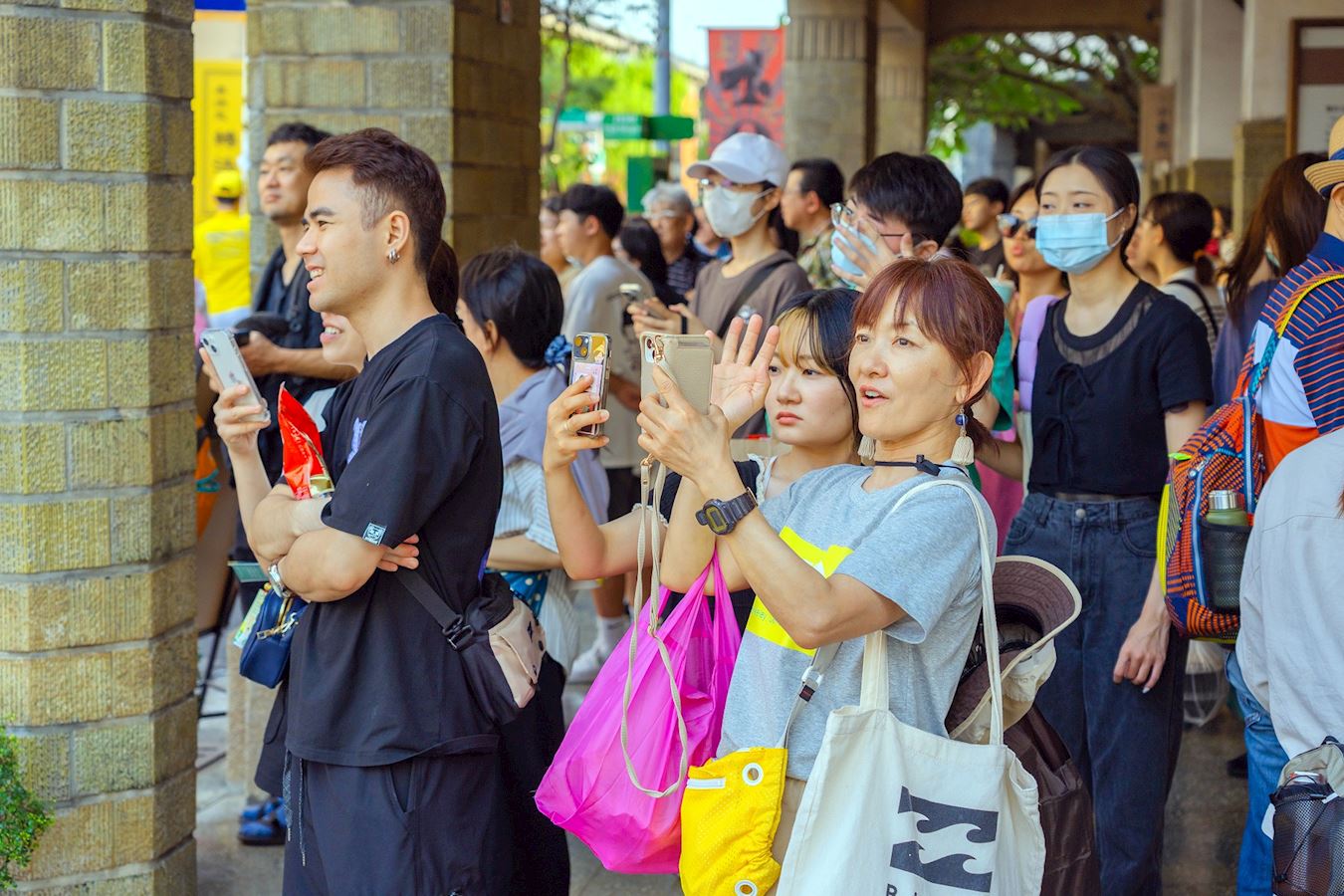 '图5:法轮功游行队伍行进中,有的民众驻足观看,有的拿起手机拍下这殊胜而美好的画面。'