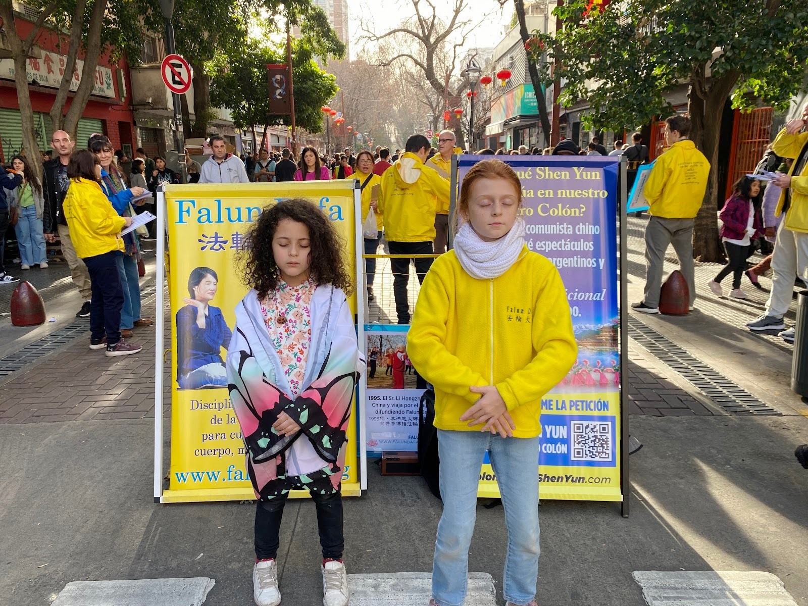图3:二零二四年五月十二日,小学员莉拉(右)在唐人街教一位小女孩炼功。