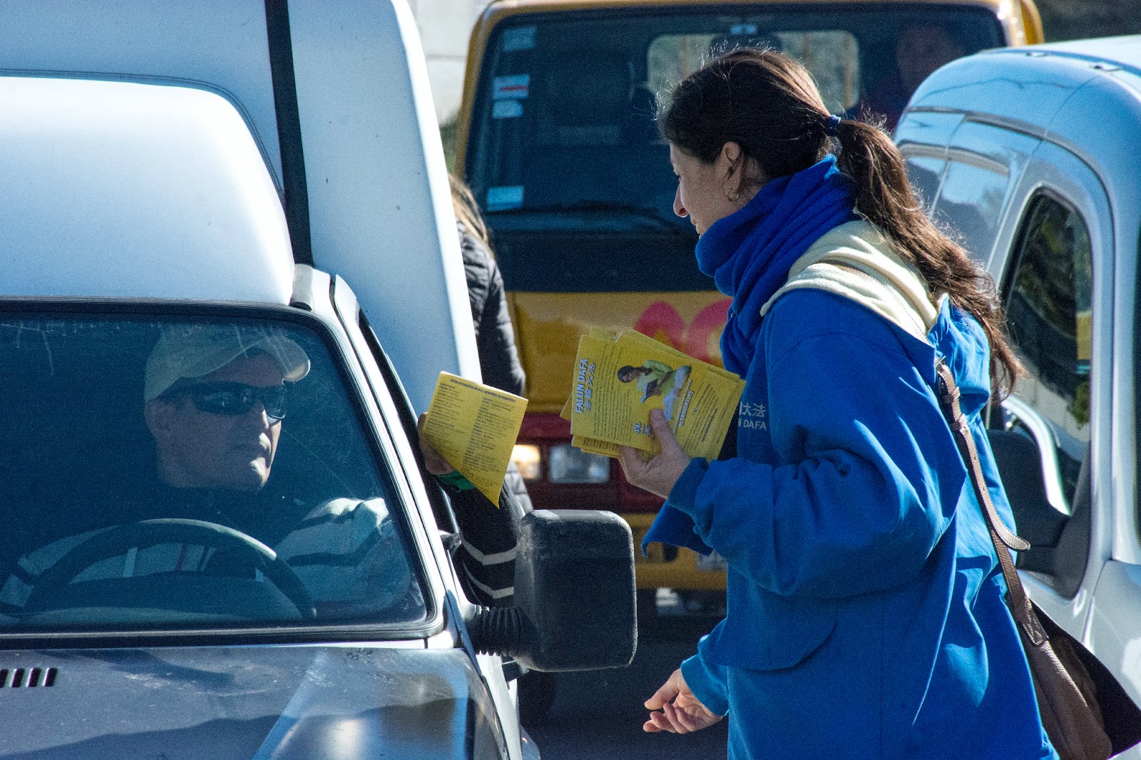 图10:学员给停在布宜诺斯艾利斯中共大使馆前的汽车司机发法轮大法传单。