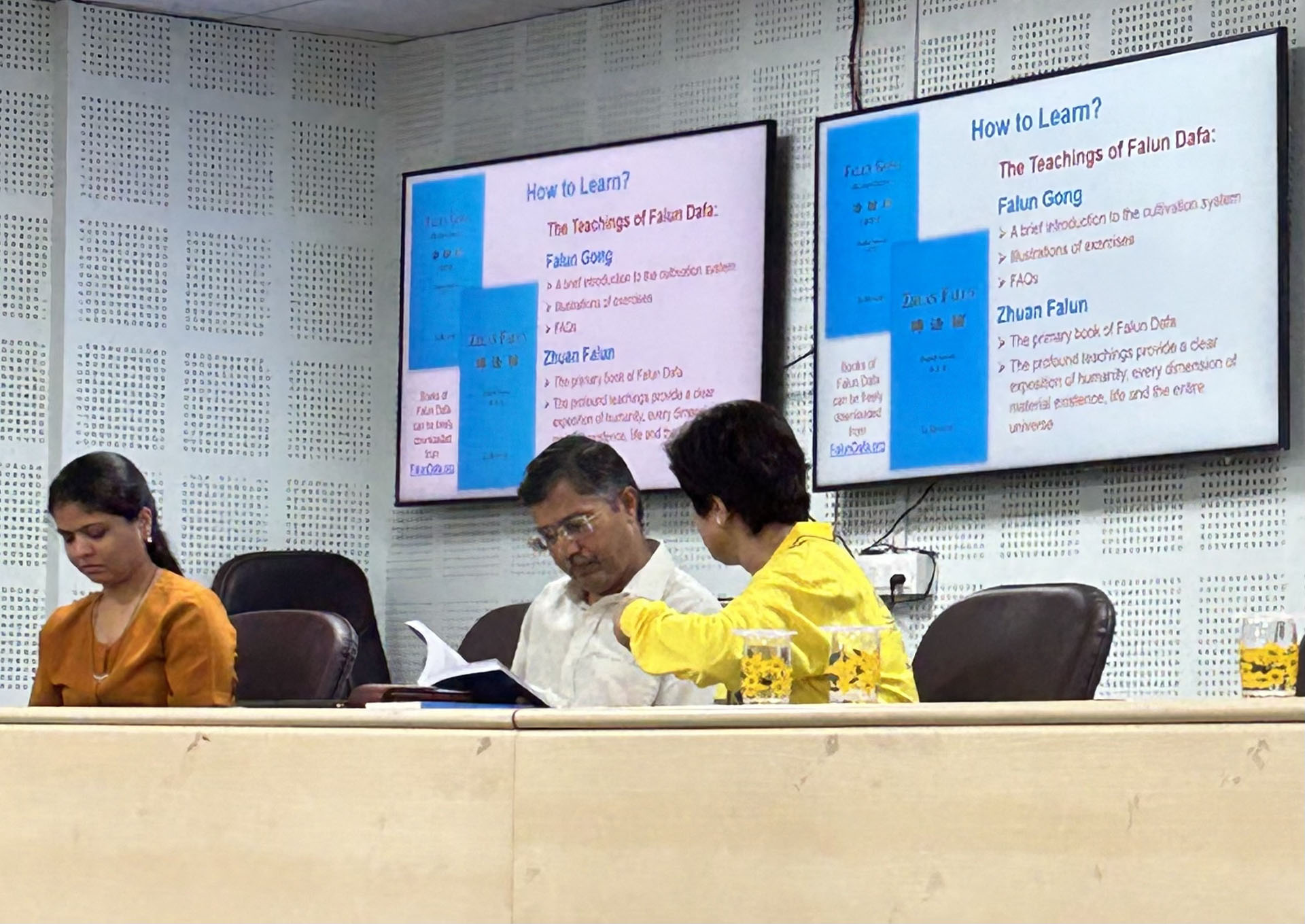 图5:VNSG大学注册主任先生拉梅什丹(中)正在阅读《转法轮》。