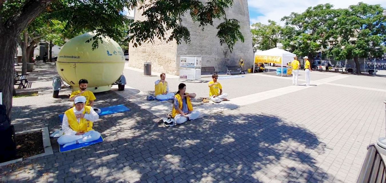'图8~9:六月十五日,学员向民众展示法轮功功法,传递法轮大法的美好,同时揭露中共对法轮功的残酷迫害真实情况。'