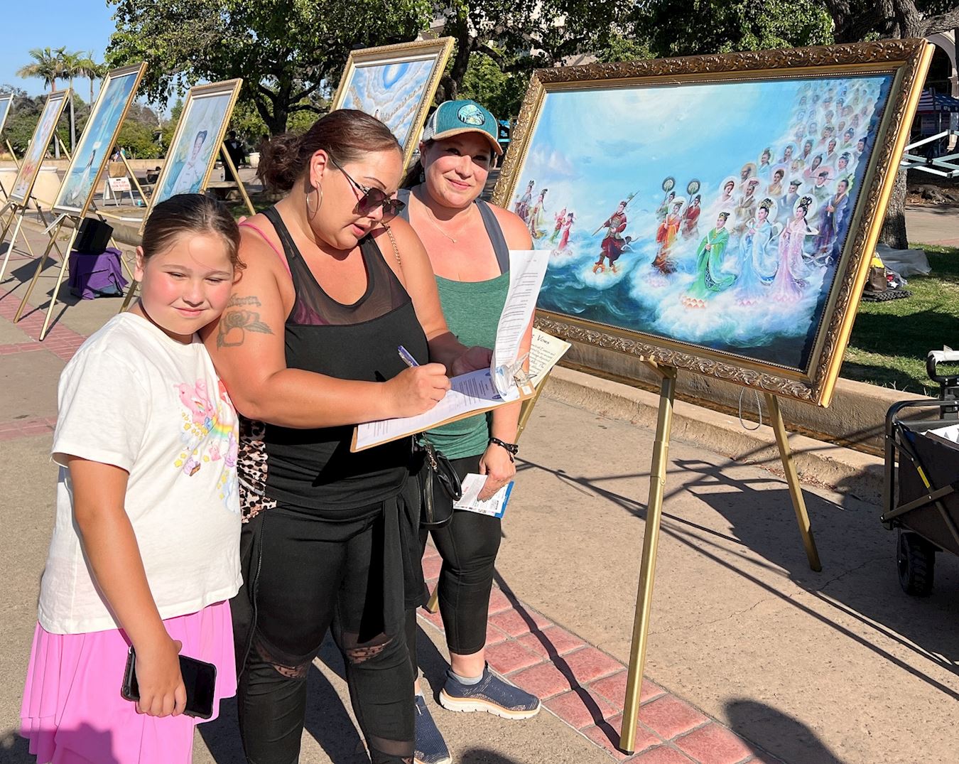 '图1~3:加州圣地亚哥法轮功学员在当地著名景点巴博亚公园举行“真善忍美展”,向当地民众和游客讲真相,’