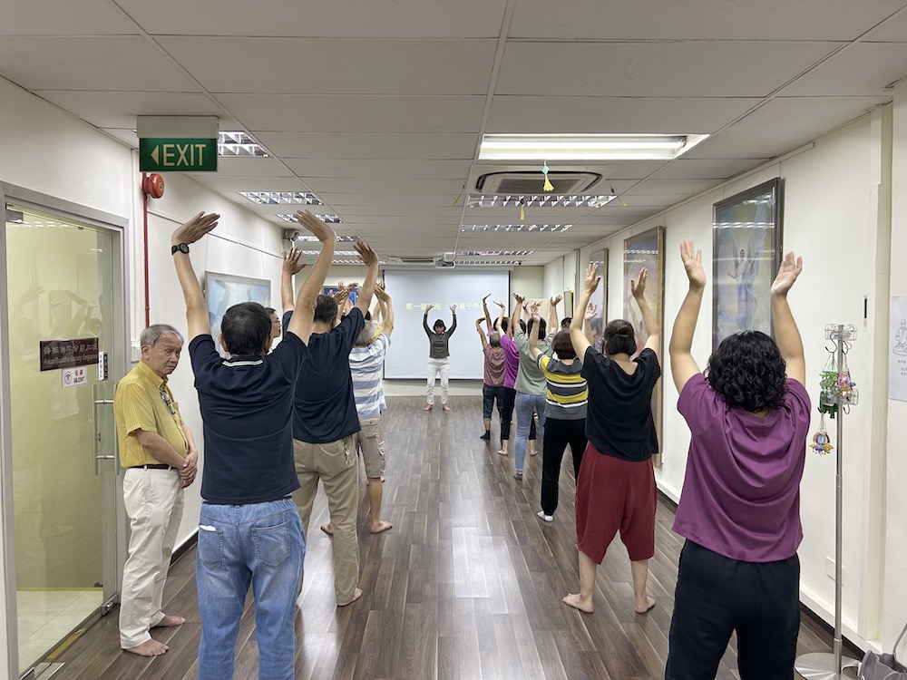 图2:参加九天班的学员正在学炼法轮功第一套功法——佛展千手法。