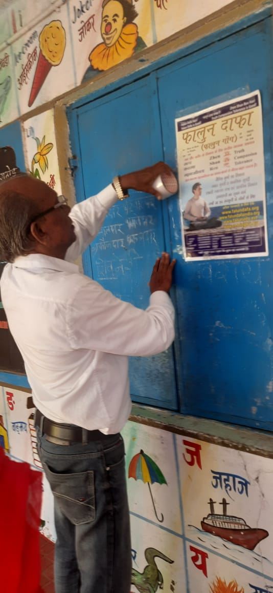 '图6:法轮功学员在布告栏上张贴宣传海报。'