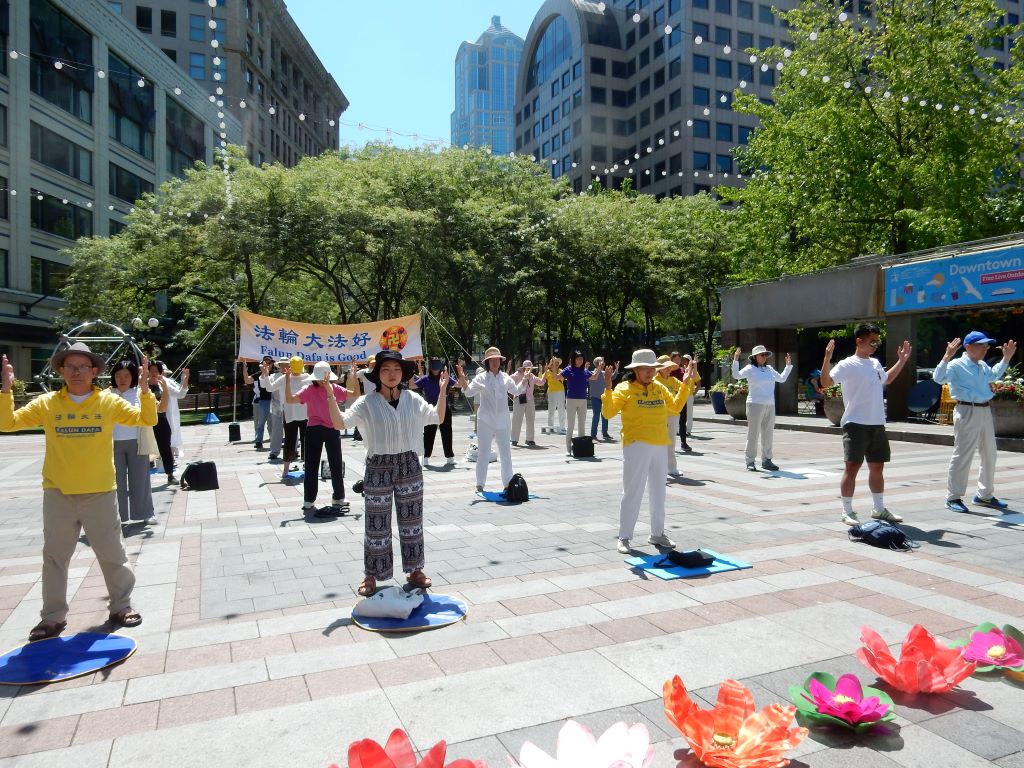图1:二零二四年七月十四日,西雅图部份法轮功学员来到西雅图市中心的西湖公园集会并集体炼功,向人们讲述和展示法轮大法的美好。图为法轮功学员在炼功。