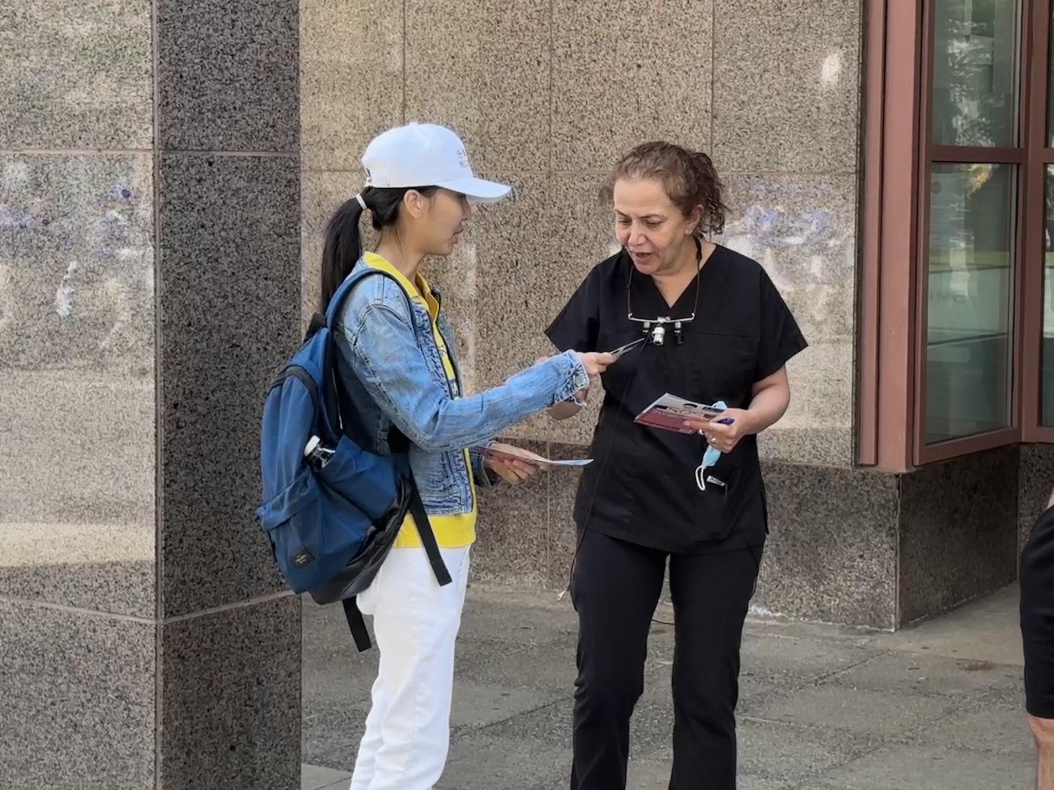 图16~18:法轮功学员向两旁的观众讲述真相,很多民众驻足观看并拍照