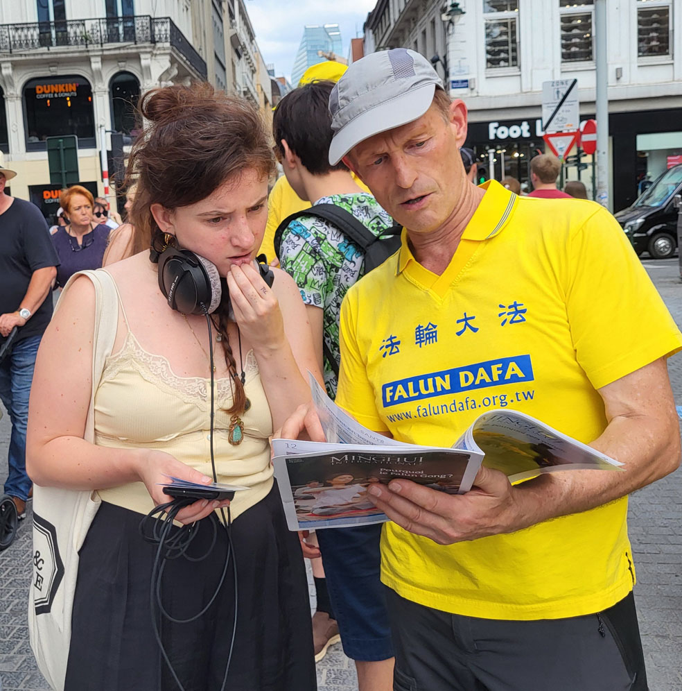 图8:劳拉(左)认真倾听学员讲解迫害真相