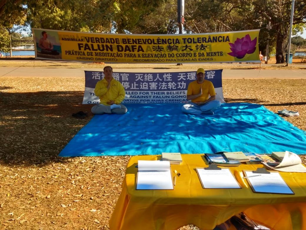 '图1:巴西利亚大法学员在巴西利亚城市公园举办反迫害25年活动'