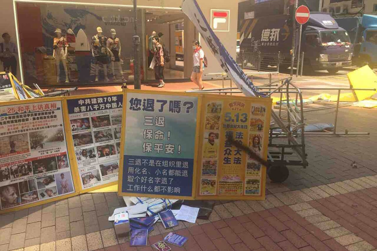 图1:二零二一年四月三日,四名歹徒在旺角豉油街法轮功真相点实施暴行,他们扯烂罗马旗,用尖刀划破展板,将黑墨喷在横幅上。