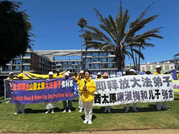 '图14:康女士在集会上呼吁紧急营救三位亲属。'