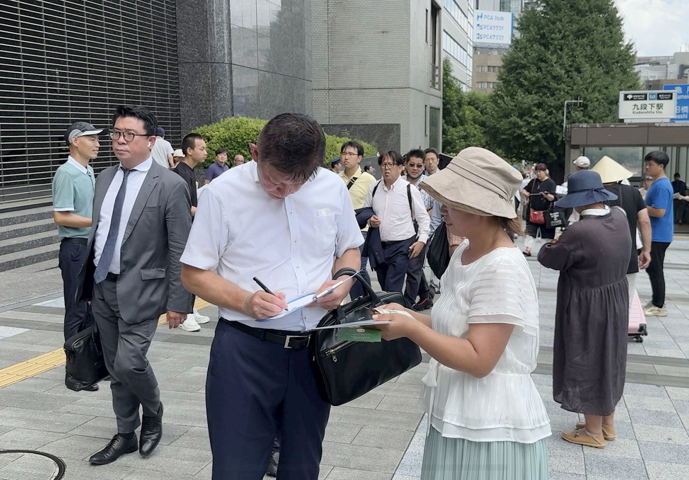 '图2~3:了解真相的日本民众,在解体中共的签名板上签名支持。'