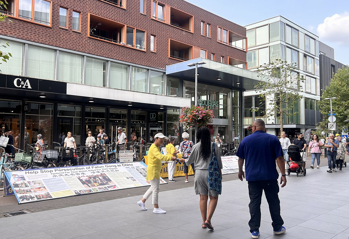 图1~3:二零二四年八月十七日,学员在Marktlaan商业区布置展板,派发传单讲真相。