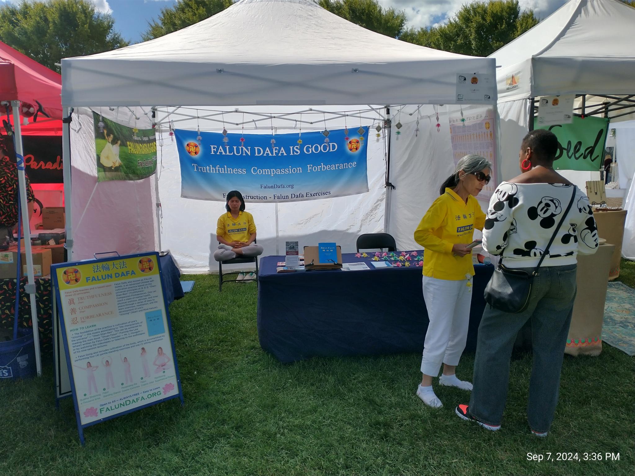 图1~2:路易斯维尔市大四艺术节法轮功展前,学员介绍功法、传递法轮功被迫害真相。