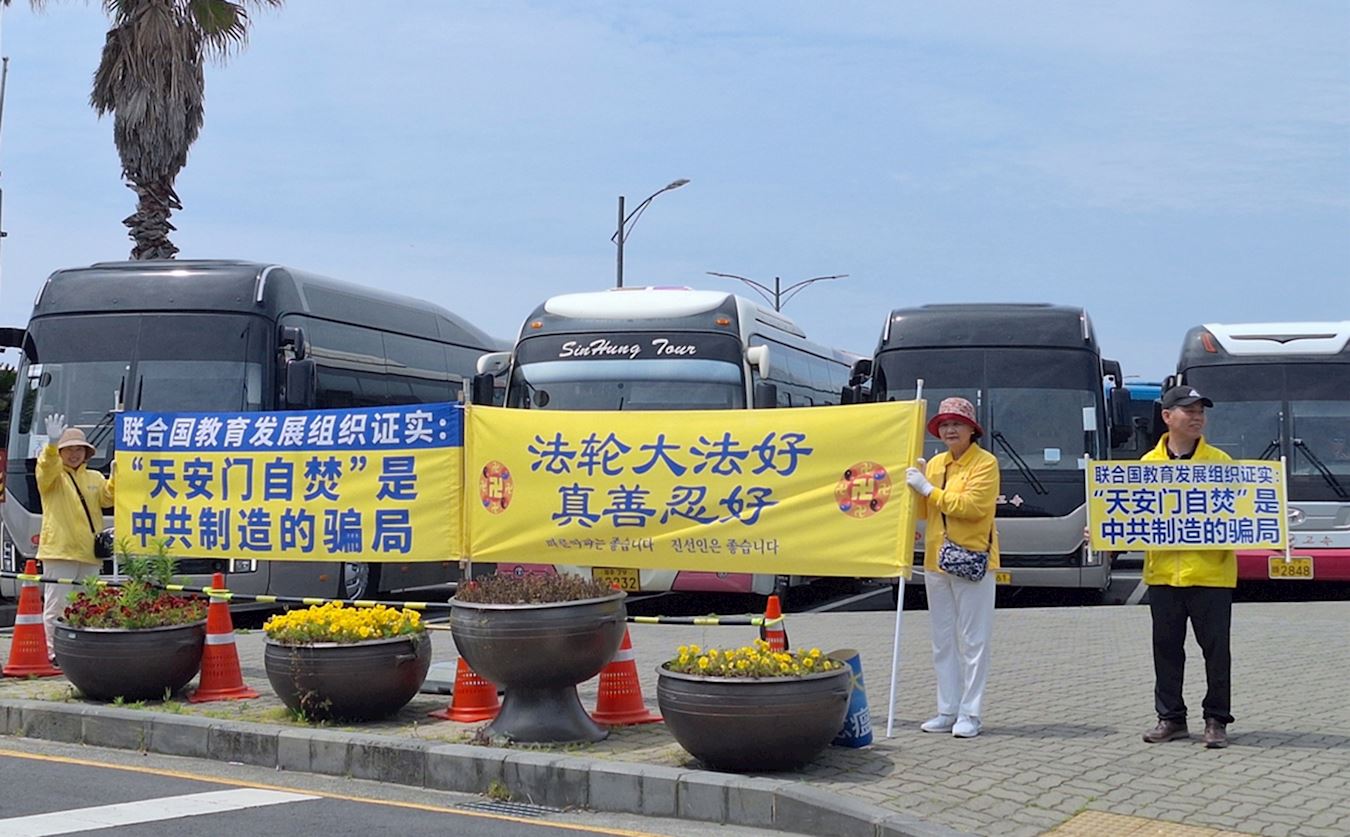 '图8:,在江汀港,法轮功学员举着横幅,让中国游客有机会看到真相。'