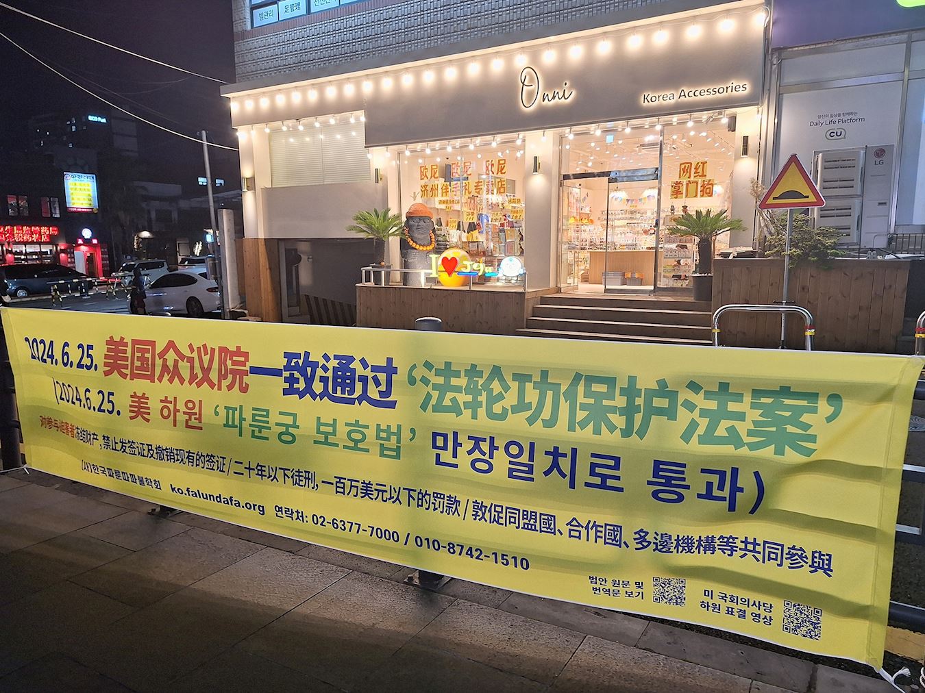 '图9:新罗免税店前悬挂的法轮功保护法案横幅。'