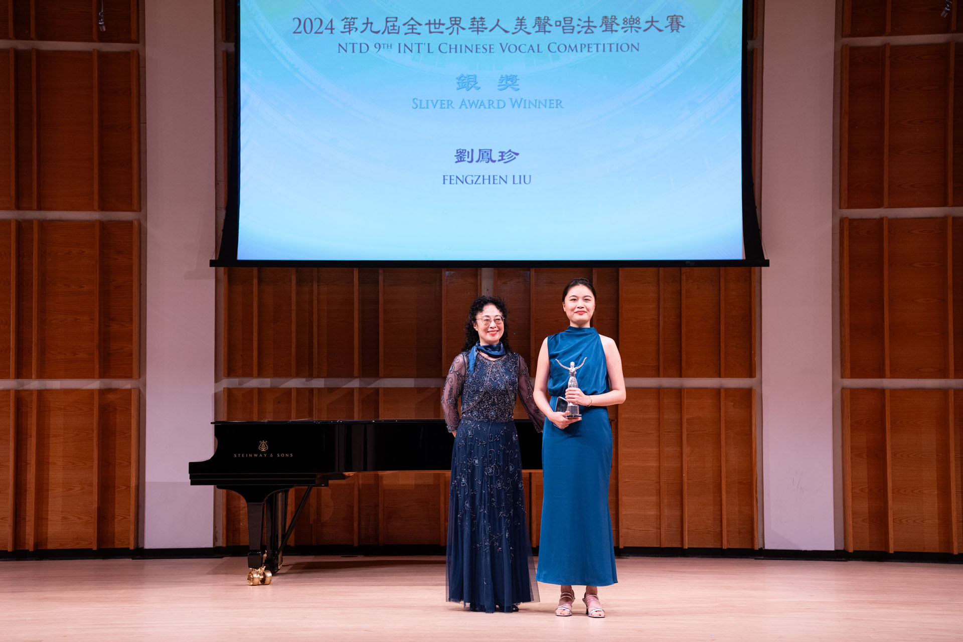 图3:在新唐人第九届全世界华人美声声乐大赛颁奖仪式上,歌唱家姜敏(左)向银奖得主刘凤珍颁奖后合影。