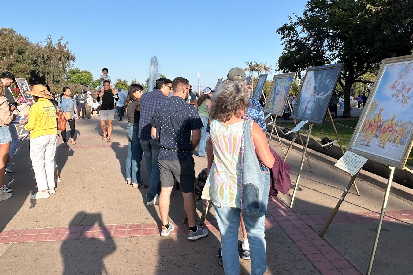 '图2~6:人们驻足真相展位观看画展,了解法轮功更多的讯息。'