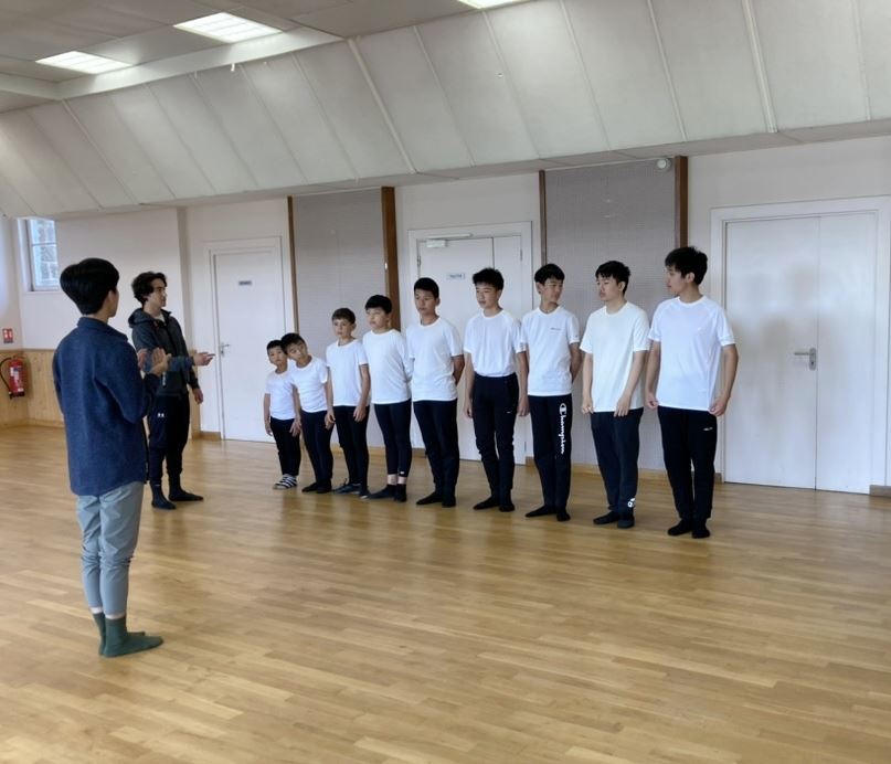 '图5:男大法小弟子在舞蹈训练中做形体训练。'