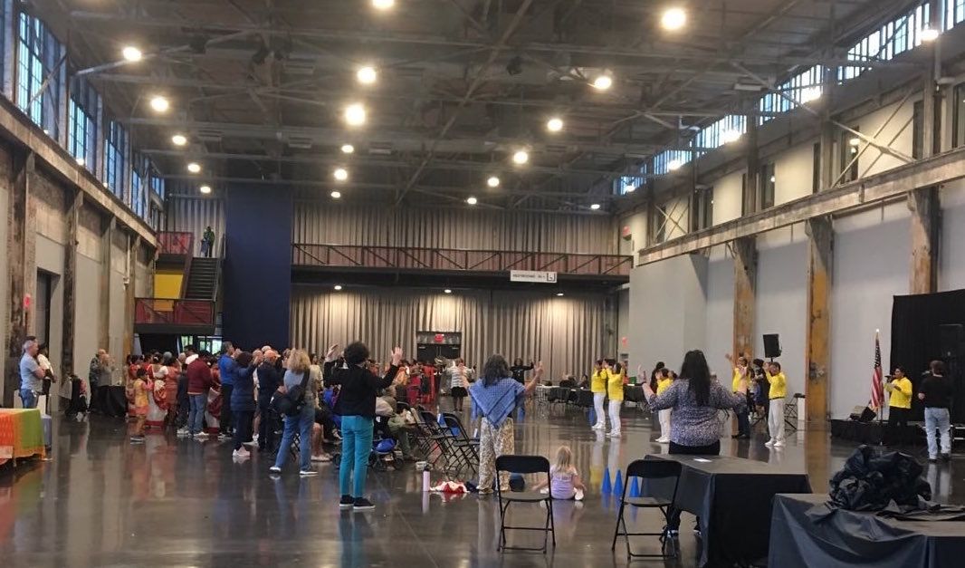 图4:法轮功学员展示法轮功功法,观众观看并跟着一起学炼