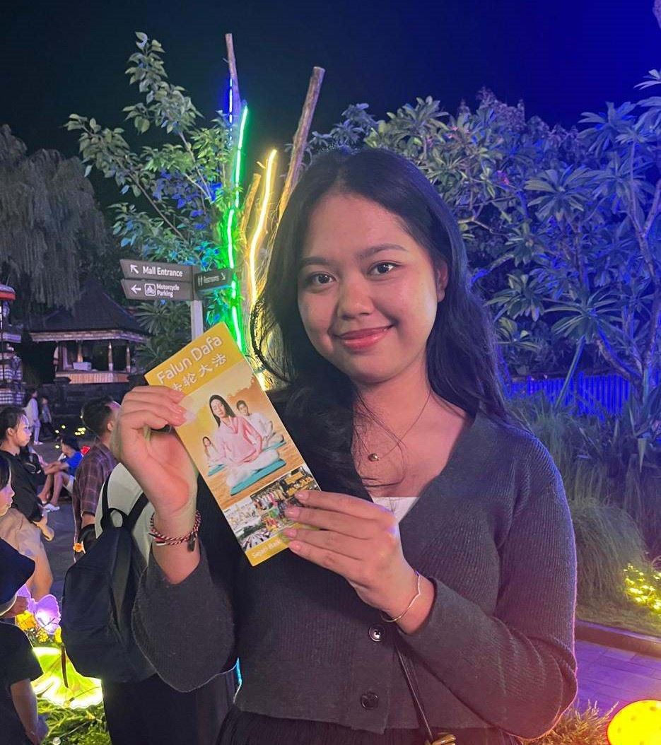 '图8:来自巴厘岛吉安雅(Gianyar)的丁达(Dinda)展示一位学员递给她的法轮功真相资料。'