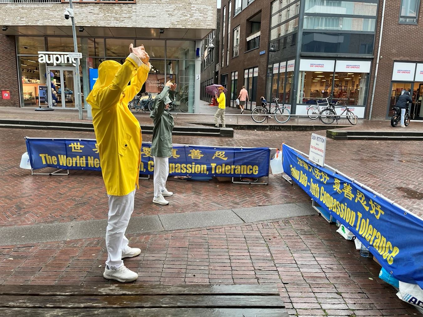 '图1~3:二零二五年九月二十日,法轮功学员在埃德(Ede)市举办信息日活动,在火车站附近的街道布置展板,展示法轮功功法,传播法轮功真相。'