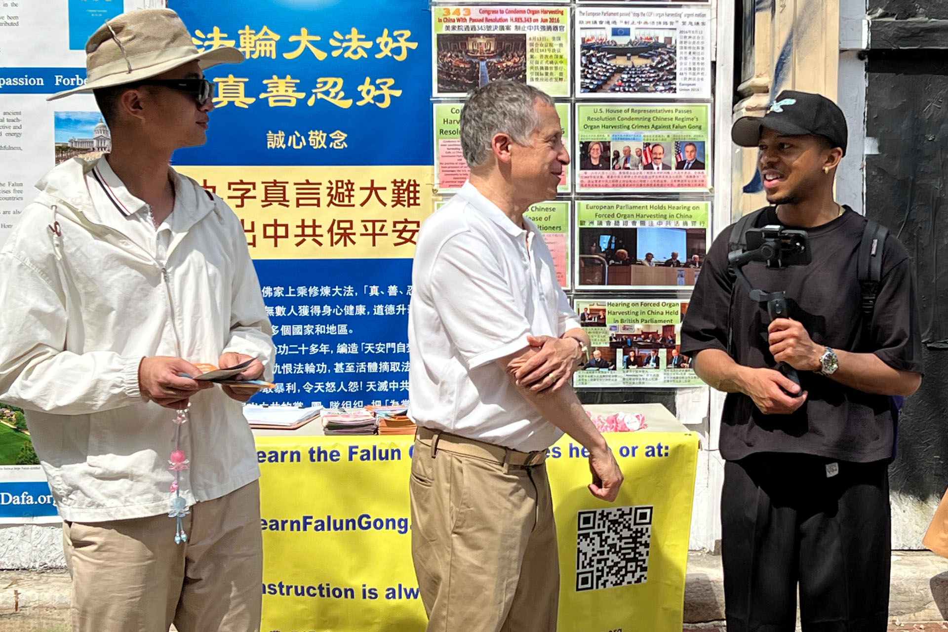 图10:博主杰姆‧罗宾逊(Jem Robinson)(右一)听法轮功学员讲述真相。