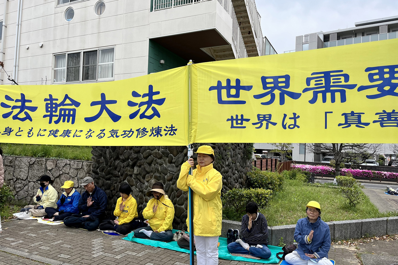 图5:法轮功学员间中(站在中间举起真相横幅)表示,秉承四·二五精神,和平请愿活动她每年都参加。