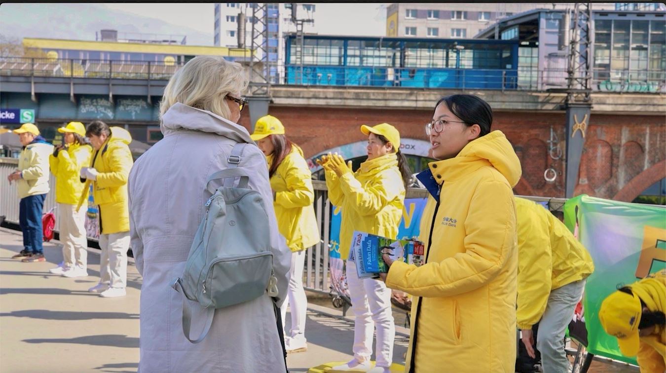 '图4:法轮功学员与路人交谈,讲述法轮功真相。'