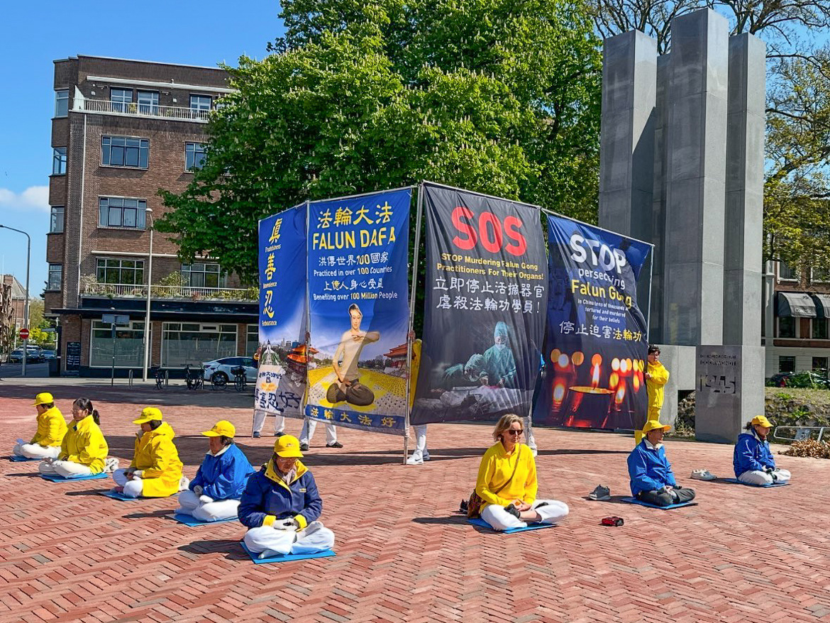 图6:四月二十五日下午,法轮功学员在和平宫景点展示功法和讲真相条幅。